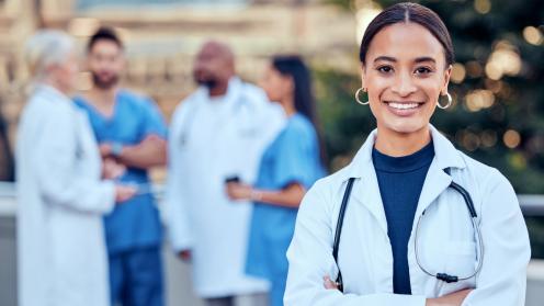 African American female physician smiling in front of her colleagues