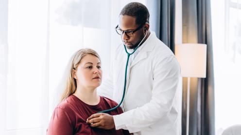 Doctor checking patient's heart with stethoscope