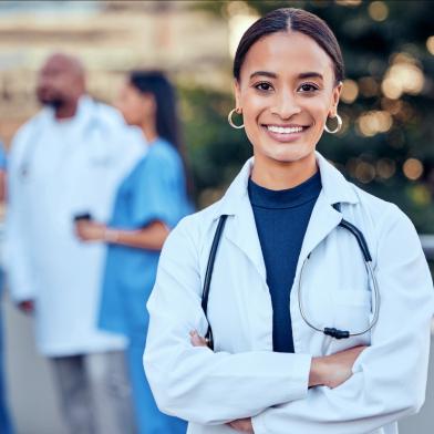 African American female physician smiling in front of her colleagues