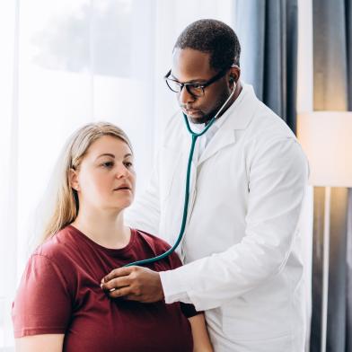 Doctor checking patient's heart with stethoscope