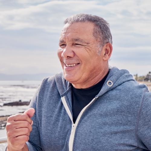 Smiling senior man running at the beach