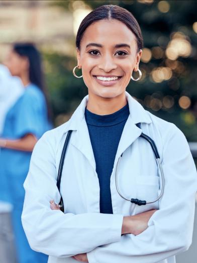 African American female physician smiling in front of her colleagues