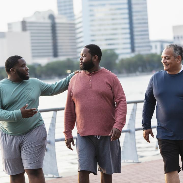 Three African American men walking along waterfront