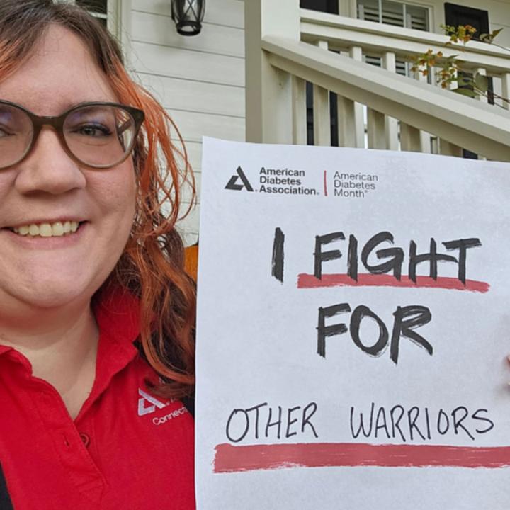 Smiling woman holding sign that says "I fight for other warriors"