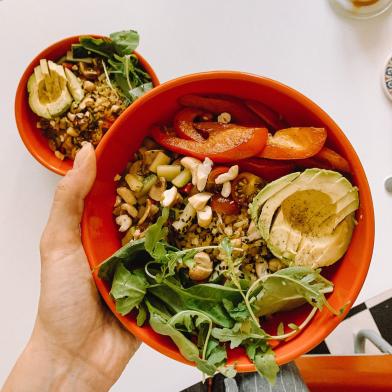 Healthy bowl of salad with vegetables and avocaco in orange bowl