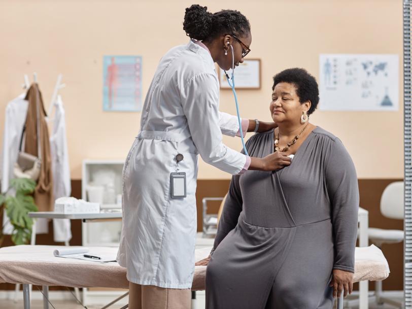 African American female physician examining a senior overweight African American female patient